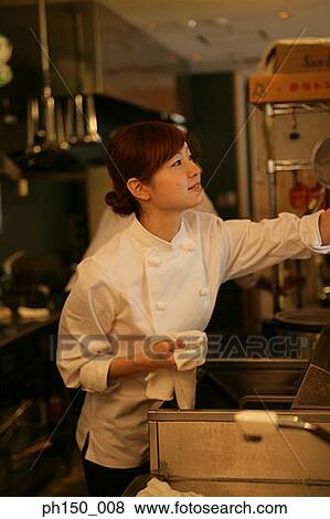 Close-up of a female chef working in the kitchen View Large Photo Image Stock Photo - Close-up of a female chef working in the kitchen. Fotosearch