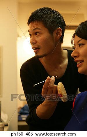 Close-up of a female fashion model with a makeup artist holding a lip liner View Large Photo Image Stock Photography - Close-up of a female fashion model with a makeup artist holding a lip liner. Fotosearch