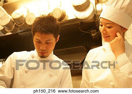 Close-up of a male chef and a female chef in the kitchen View Large Photo Image Stock Photograph - Close-up of a male chef and a female chef in the kitchen. Fotosearch