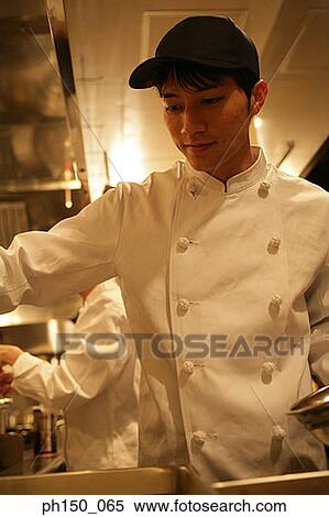 Close-up of a male chef and his colleague preparing food View Large Photo Image Stock Photography - Close-up of a male chef and his colleague preparing food. Fotosearch