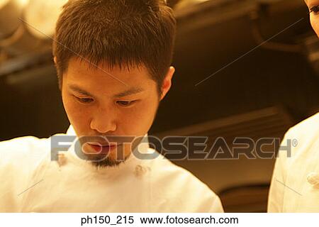 Close-up of a male chef and his colleague in the kitchen View Large Photo Image Stock Photography - Close-up of a male chef and his colleague in the kitchen. Fotosearch