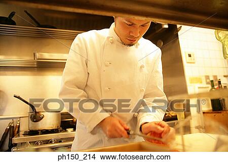 Picture - Close-up of a male chef cutting vegetables. Fotosearch