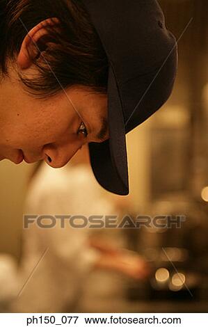 Close-up of a male chef looking down View Large Photo Image Stock Photo - Close-up of a male chef looking down. Fotosearch
