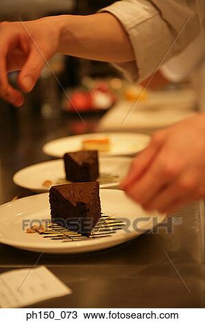 Close-up of a person's hands over a plate of chocolate cake View Large Photo Image Stock Image - Close-up of a person's hands over a plate of chocolate cake. Fotosearch