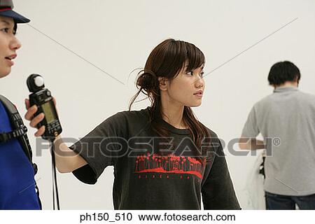Close-up of a photographer using a light meter in front of a female fashion model View Large Photo Image Stock Image - Close-up of a photographer using a light meter in front of a female fashion model. Fotosearch