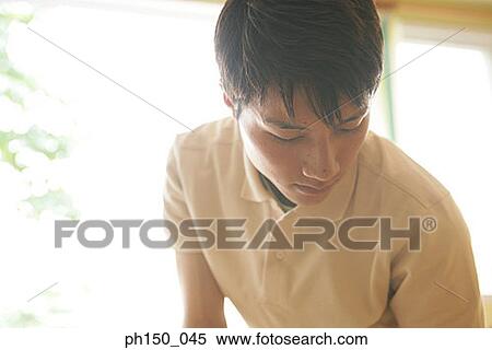 Close-up of a waiter looking down View Large Photo Image Stock Photography - Close-up of a waiter looking down. Fotosearch