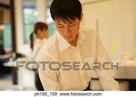 Close-up of a waiter standing in a restaurant View Large Photo Image Stock Photo - Close-up of a waiter standing in a restaurant. Fotosearch