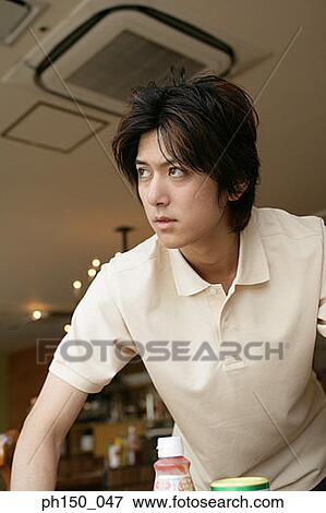 Close-up of a waiter working in a restaurant and looking away View Large Photo Image Stock Photo - Close-up of a waiter working in a restaurant and looking away. Fotosearch