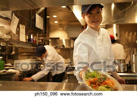Close-up of a waitress holding a plate of food View Large Photo Image Stock Photograph - Close-up of a waitress holding a plate of food. Fotosearch