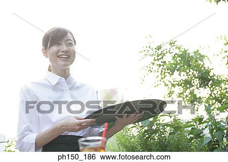 Close-up of a waitress holding a serving tray and smiling View Large Photo Image Stock Photograph - Close-up of a waitress holding a serving tray and smiling. Fotosearch