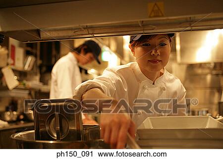 Close-up of a waitress holding tongs with a waiter standing behind her View Large Photo Image Stock Image - Close-up of a waitress holding tongs with a waiter standing behind her. Fotosearch