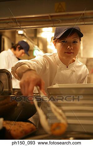 Close-up of a waitress picking up snacks with a waiter standing in the background View Large Photo Image Stock Image - Close-up of a waitress picking up snacks with a waiter standing in the background. Fotosearch