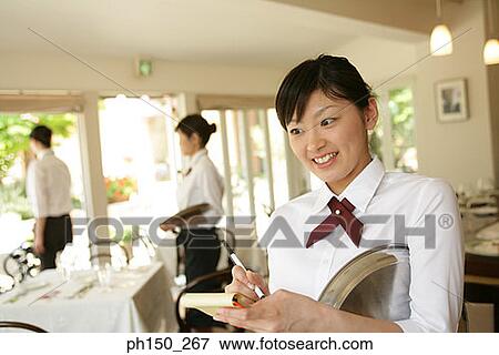 Stock Photo - Close-up of a waitress taking an order and smiling. Fotosearch