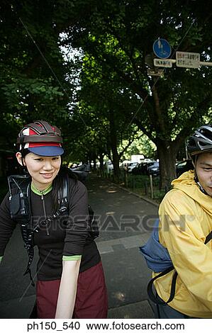 Close-up of a young couple wearing cycling helmets View Large Photo Image Stock Image - Close-up of a young couple wearing cycling helmets. Fotosearch