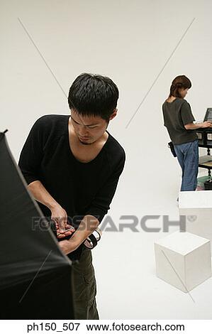 Close-up of a young man adjusting lighting equipment in a film studio View Large Photo Image Stock Photo - Close-up of a young man adjusting lighting equipment in a film studio. Fotosearch