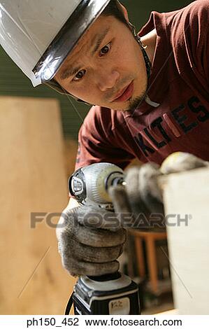 Close-up of a young man drilling a hole in wood View Large Photo Image Stock Image - Close-up of a young man drilling a hole in wood. Fotosearch