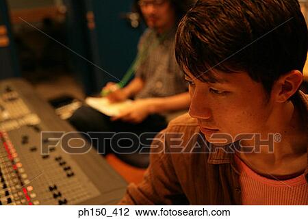 Stock Image - Close-up of a young man in a recording studio. Fotosearch