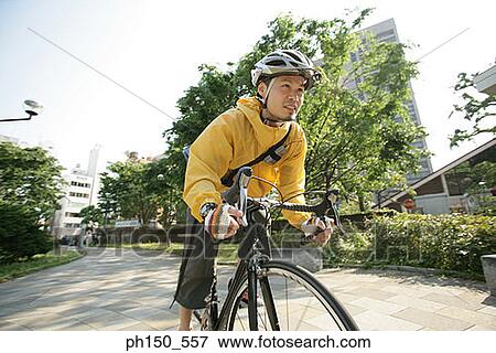Close-up of a young man riding a bicycle View Large Photo Image Stock Photo - Close-up of a young man riding a bicycle. Fotosearch