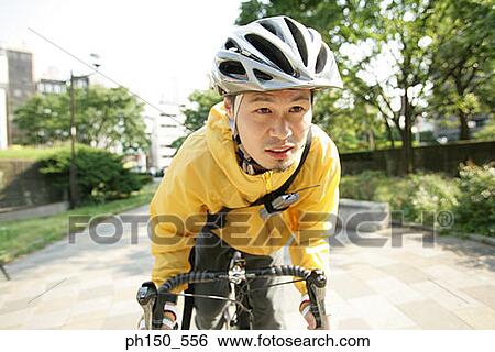 Stock Photograph - Close-up of a young man riding a bicycle. Fotosearch