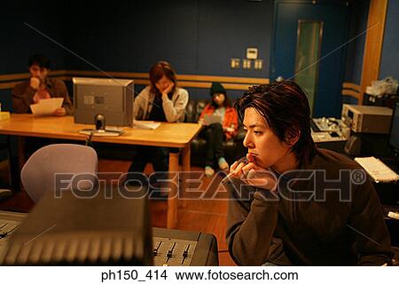 Close-up of a young man thinking with his hand on his chin in a recording studio View Large Photo Image Picture - Close-up of a young man thinking with his hand on his chin in a recording studio. Fotosearch