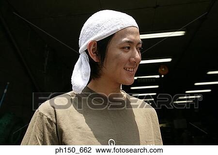 Close-up of an auto mechanic looking away and smiling View Large Photo Image Stock Image - Close-up of an auto mechanic looking away and smiling. Fotosearch