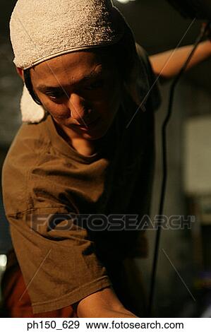 Close-up of an auto mechanic looking down View Large Photo Image Stock Photo - Close-up of an auto mechanic looking down. Fotosearch