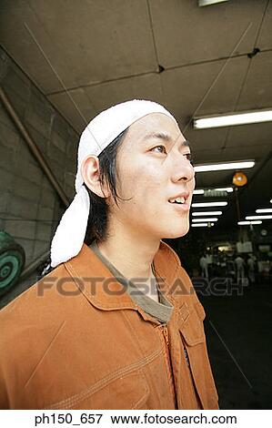 Close-up of an auto mechanic looking away View Large Photo Image Stock Photo - Close-up of an auto mechanic looking away. Fotosearch