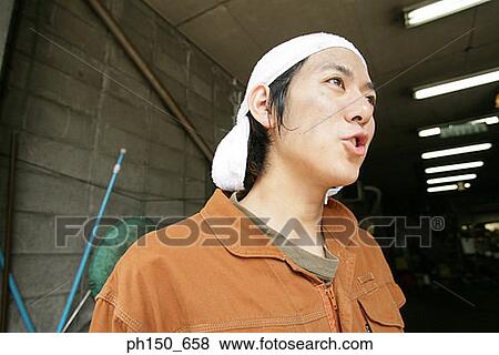 Close-up of an auto mechanic looking away View Large Photo Image Stock Photo - Close-up of an auto mechanic looking away. Fotosearch