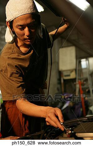 Close-up of an auto mechanic repairing a car View Large Photo Image Stock Photo - Close-up of an auto mechanic repairing a car. Fotosearch
