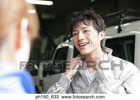 Close-up of an auto mechanic standing in an auto repair shop and smiling View Large Photo Image Stock Image - Close-up of an auto mechanic standing in an auto repair shop and smiling. Fotosearch