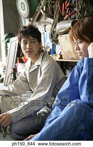 Close-up of two auto mechanics sitting in an auto repair shop View Large Photo Image Picture - Close-up of two auto mechanics sitting in an auto repair shop. Fotosearch