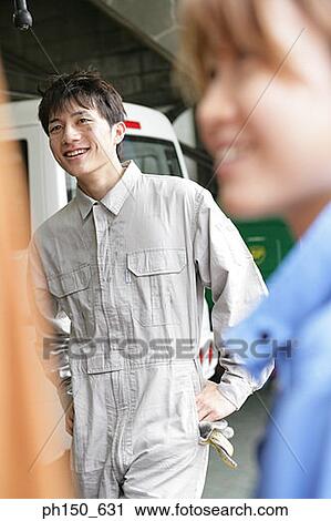 Close-up of two auto mechanics standing in an auto repair shop and smiling View Large Photo Image Stock Image - Close-up of two auto mechanics standing in an auto repair shop and smiling. Fotosearch