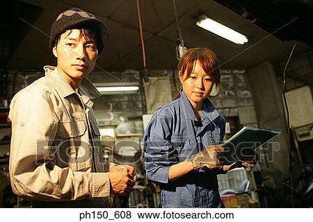 Close-up of two auto mechanics standing in an auto repair shop View Large Photo Image Stock Photo - Close-up of two auto mechanics standing in an auto repair shop. Fotosearch
