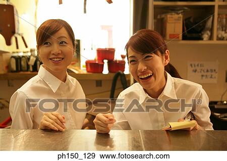 Close-up of two waitresses standing at a kitchen counter View Large Photo Image Stock Photo - Close-up of two waitresses standing at a kitchen counter. Fotosearch