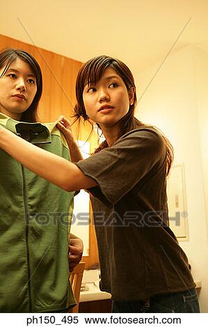 Fashion designer assisting a female fashion try on a jacket View Large Photo Image Stock Photography - Fashion designer assisting a female fashion try on a jacket. Fotosearch