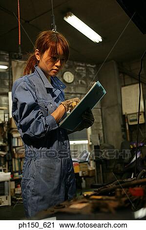 Female auto mechanic standing in front of a car and holding a clipboard View Large Photo Image Stock Image - Female auto mechanic standing in front of a car and holding a clipboard. Fotosearch