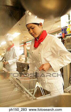 Female chef cooking food in the kitchen View Large Photo Image Stock Image - Female chef cooking food in the kitchen. Fotosearch