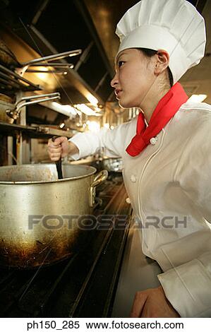 Female chef cooking food in the kitchen View Large Photo Image Stock Photography - Female chef cooking food in the kitchen. Fotosearch