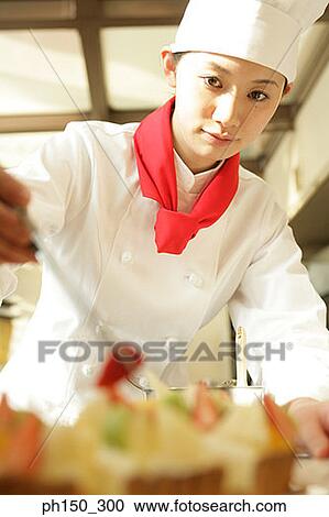 Female chef decorating a tart with a slice of strawberry View Large Photo Image Stock Image - Female chef decorating a tart with a slice of strawberry. Fotosearch
