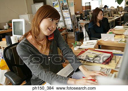 High angle view of a businesswoman using a mobile phone in an office View Large Photo Image Picture - High angle view of a businesswoman using a mobile phone in an office. Fotosearch