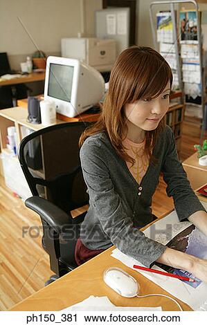 Stock Image - High angle view of a businesswoman working in an office. Fotosearch