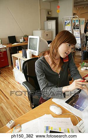 High angle view of a businesswoman using a mobile phone in an office View Large Photo Image Stock Image - High angle view of a businesswoman using a mobile phone in an office. Fotosearch