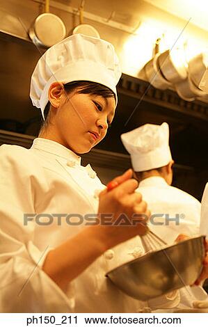 Low angle view of a female chef holding a wire whisk with a mixing bowl View Large Photo Image Stock Image - Low angle view of a female chef holding a wire whisk with a mixing bowl. Fotosearch
