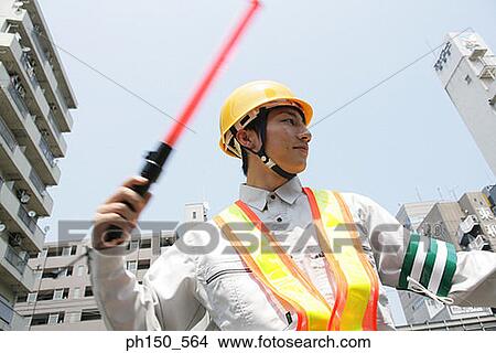 Picture - Low angle view of a traffic cop holding a nightstick. Fotosearch