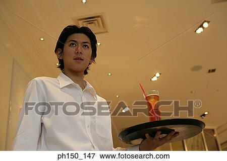 Low angle view of a waiter holding a tray View Large Photo Image Stock Photo - Low angle view of a waiter holding a tray. Fotosearch