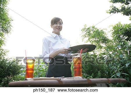 Low angle view of a waitress holding a serving tray and smiling View Large Photo Image Stock Photo - Low angle view of a waitress holding a serving tray and smiling. Fotosearch