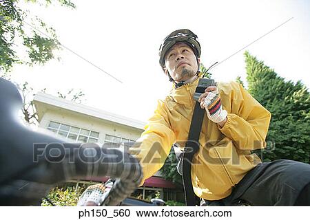 Low angle view of a young man talking on a walky talky View Large Photo Image Stock Image - Low angle view of a young man talking on a walky talky. Fotosearch