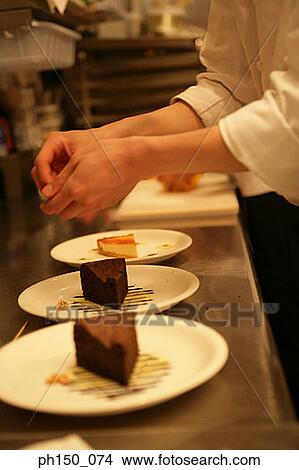 Mid section view of a female chef's hands over a plate of chocolate cake View Large Photo Image Picture - Mid section view of a female chef's hands over a plate of chocolate cake. Fotosearch