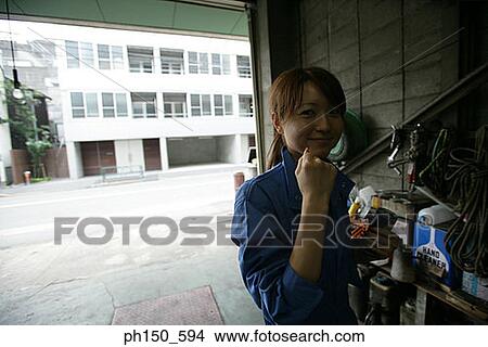 Portrait of a female auto mechanic showing her fist and smiling View Large Photo Image Picture - Portrait of a female auto mechanic showing her fist and smiling. Fotosearch