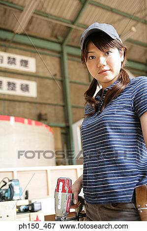 Portrait of a female carpenter holding a drill machine View Large Photo Image Stock Photo - Portrait of a female carpenter holding a drill machine. Fotosearch